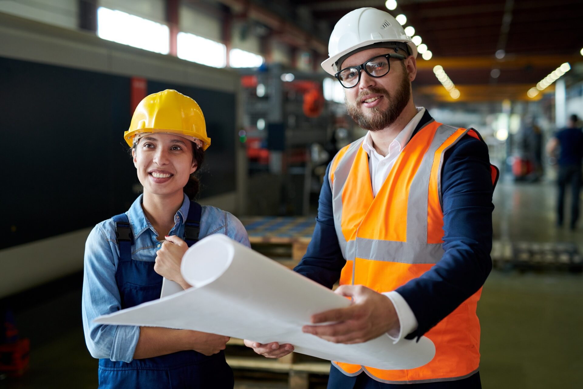 Smiling Engineers Holding Blueprints